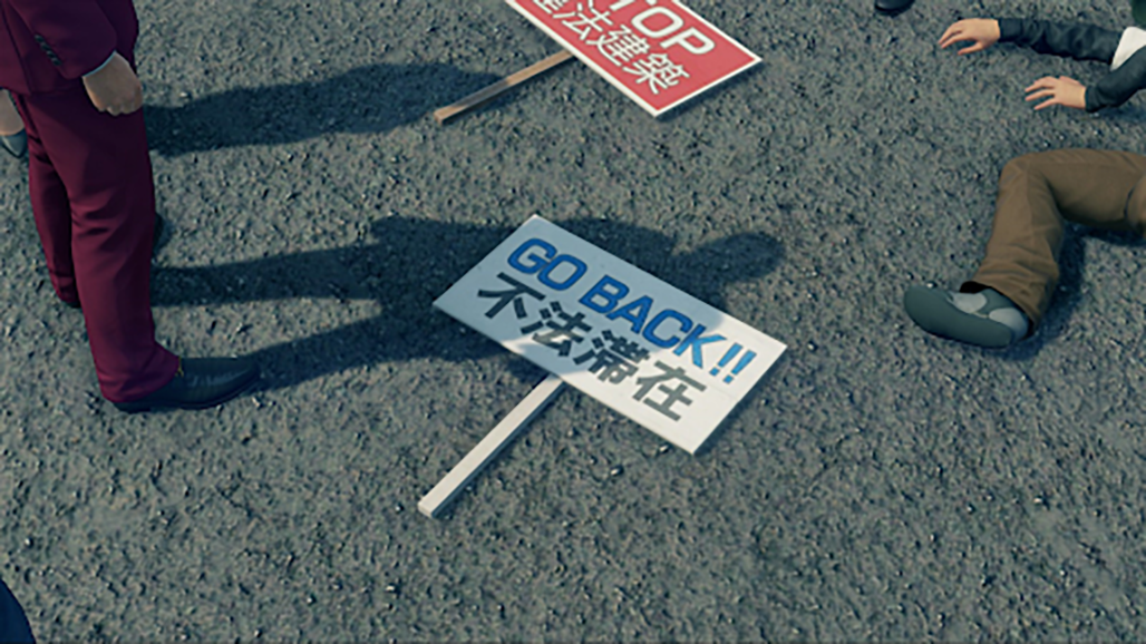 Picket signs on the ground that have anti-immigration messages like "go back!!!" on them