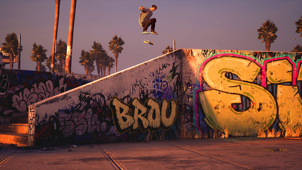 A skater mid-jump with his board hanging in mid-air above a graffitied stairwell