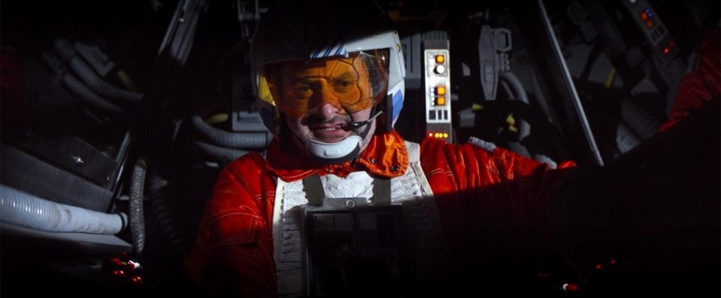 A rebel pilot in his cockpit grinning at the camera