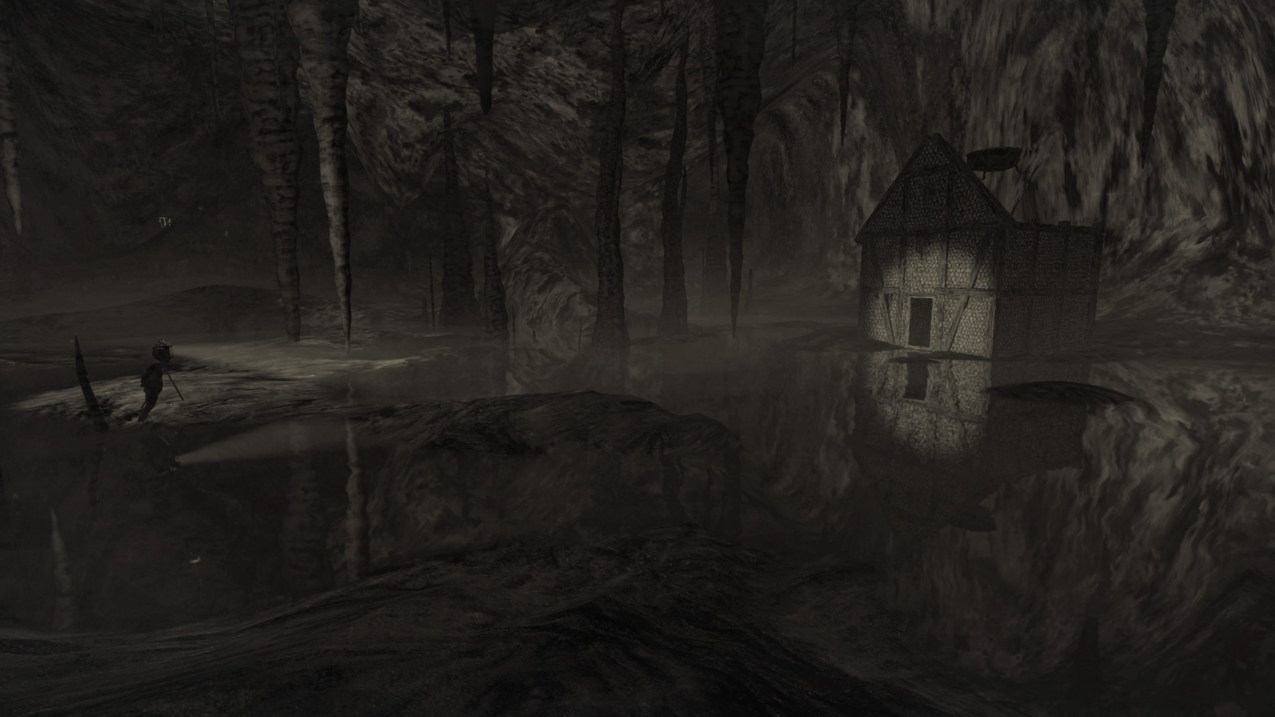 A screenshot of a house within a dark cave from Mundaun