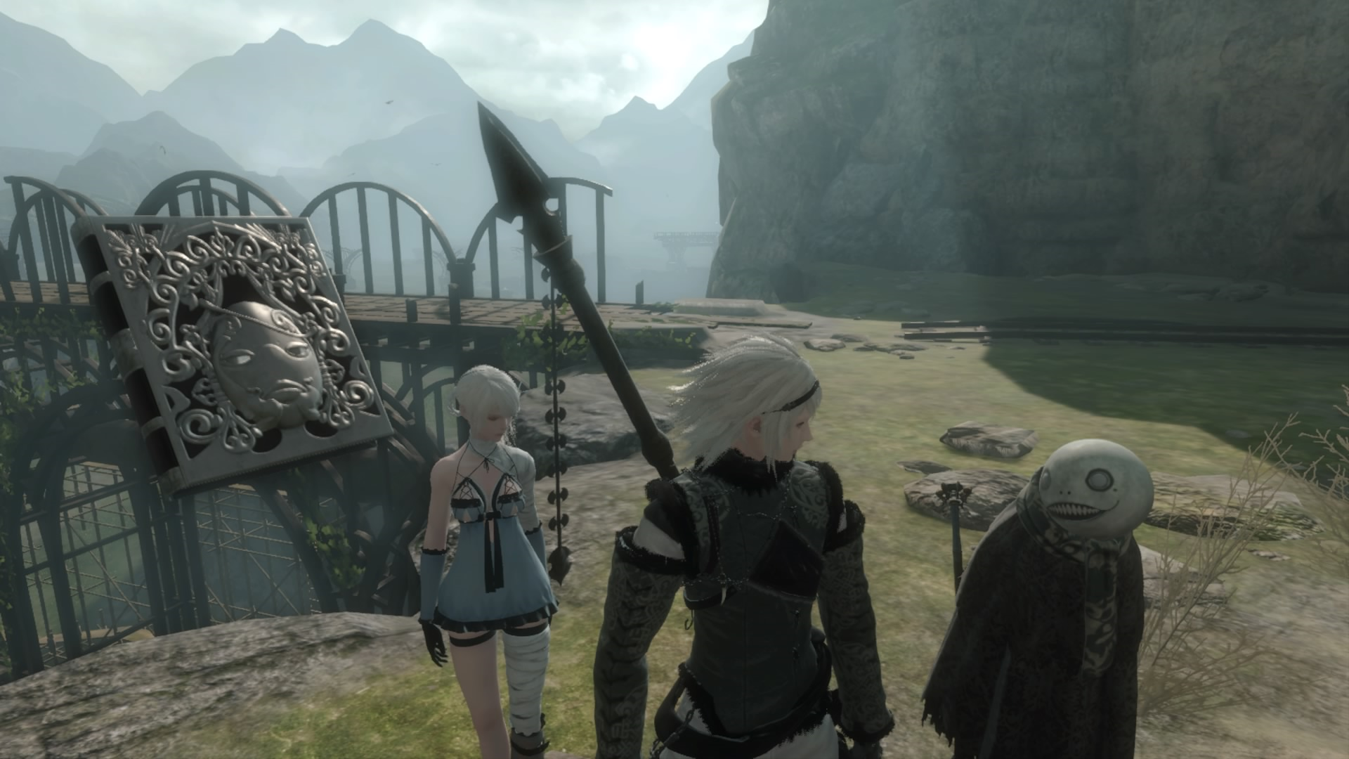 A screenshot of the three main characters from Nier 1.22... walking outside with a cliff and a bridge behind them