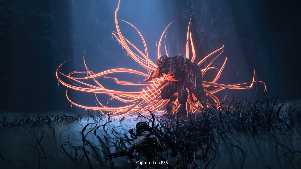 Selene hiding in the grass from a giant black enemy with red glowing tentacles
