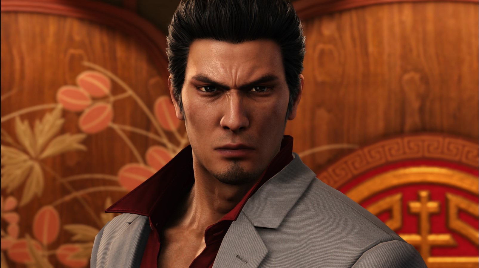 Kazuma Kiryu in a red shirt and gray suit jacket